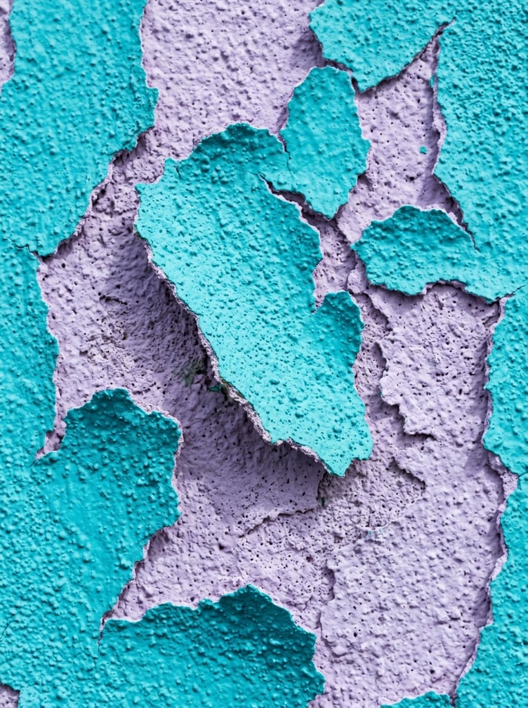 macro close-up of peeling textured surface, bright turquoise irregular organic shapes over a light lavender purple background, heavy stippled porous stucco texture on all layers, raised jagged edges with soft drop shadows, vertical orientation, vibrant color contrast, abstract tactile composition