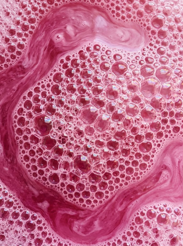 Texture of pink liquid with bubbles, pattern, background, top view, organic texture, seamless texture, rich colors, gradation of pink colors, macro photo, cluster of bubbles